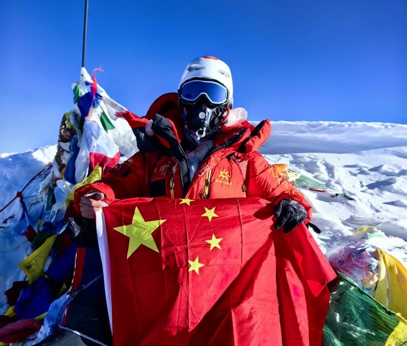 朱霞（考拉姐）手持国旗于 2023 年 5 月 18 日登顶珠穆朗玛峰
